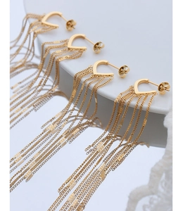Detailed close-up of golden heart tassel earrings with long metallic fringe chains