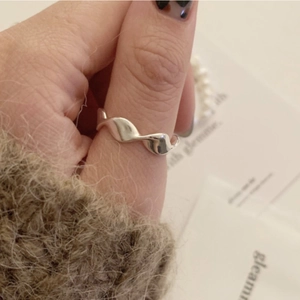 Minimalist silver wavy twisted ring for women worn on finger in a polished finish
