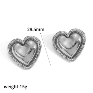 Macro shot of silver heart earrings with 28.5mm size and ribbed textured details