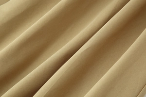 Gros plan détaillé de la texture du tissu sergé kaki montrant le drapé et les détails