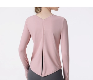 Back view of pink long sleeve sports top featuring deep V-neck and split hem detail