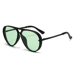Detail view of aviator sunglasses featuring a matte black frame and green transparent lenses