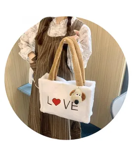 Detail of white plush tote bag with brown handles and embroidered LOVE text with red heart