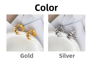 Detail view of C-shaped 18K gold plated earrings with smooth wavy texture and polished finish