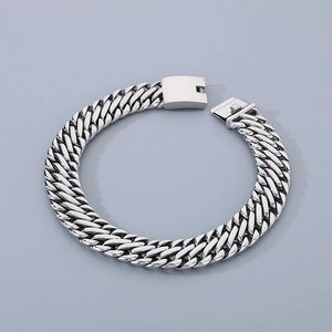 Detailed close-up of a silver stainless steel braided Cuban chain bracelet with clasp
