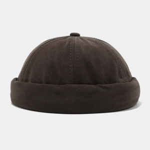 Detail of the stitched dark brown cotton brimless docker hat with a retro texture