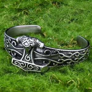 Detailed relief of Viking Mjolnir and Norse patterns on a vintage steel cuff bracelet