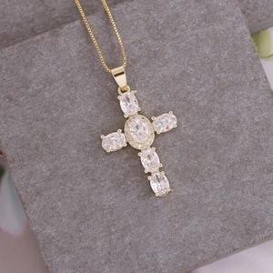Macro shot of 18K gold plated cross pendant with cubic zirconia on a box chain