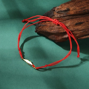 Close-up of red braided rope bracelet with Palestine map charm on a wood block