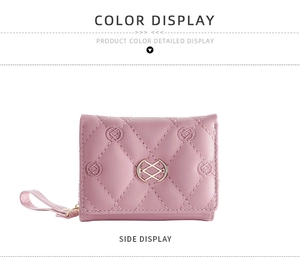 Detail view of pink quilted short wallet with gold metal clasp and leather wrist strap