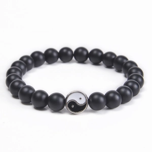 Detail of 8mm matte black stone beads with a classic Yin Yang charm on an elastic cord