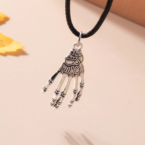 Detailed view of an antique silver skeleton hand pendant on a black cord necklace