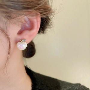 Macro detail of the apple-shaped stud earring with pink pearl finish and tiny leaf diamonds
