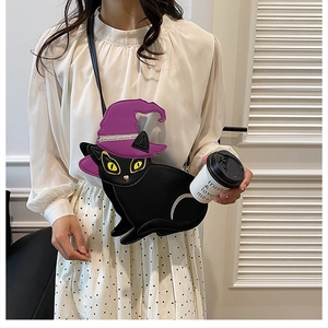 Détail du sac bandoulière chat noir avec chapeau de sorcière porté par un mannequin
