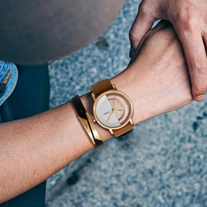 TOMI hollow design quartz watch with brown leather strap and matching bracelet on wrist