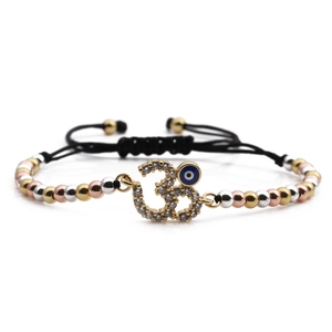 Adjustable boho devil eye bracelet with gold beads, Om symbol, and blue charm on black rope
