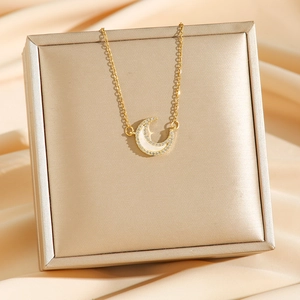 Gold moon pendant necklace with white shell inlay and zircon accents on silk