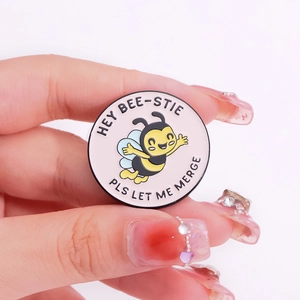 Round bee enamel pin featuring Hey Bee-stie text and cute cartoon animal design