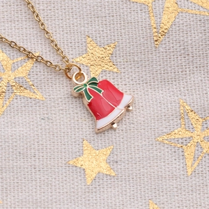 Christmas jewelry set with red bell pendant necklace and green bow on star background