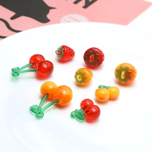 Macro shot of colorful resin strawberry and cherry charms for DIY jewelry crafting
