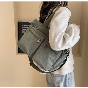 Detail of green corduroy shoulder bag showing fabric texture and adjustable strap