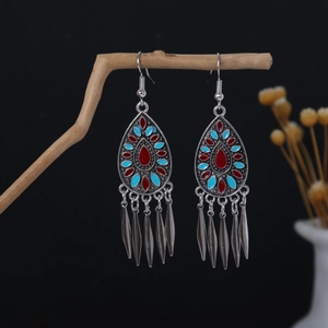 Detailed view of bohemian teardrop earrings with colorful enamel and silver tassels