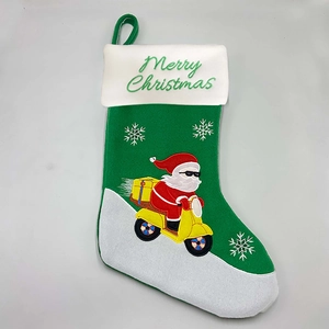 Detail of green Christmas stocking featuring a skateboarding Santa Claus and white plush cuff