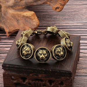 Macro detail of antique gold tiger head link bracelet on textured wood base