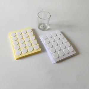 Close-up of double-sided adhesive dots for secure candle wick placement in DIY crafts