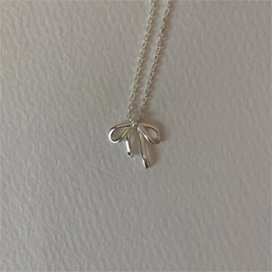 Close-up of a 925 sterling silver bow pendant necklace with detailed polished finish