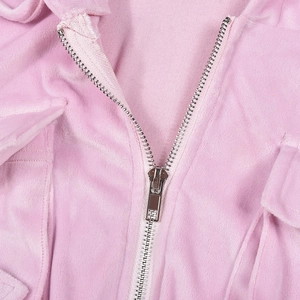 Detail of silver metal zipper and soft pink velvet texture on a hooded sweatshirt
