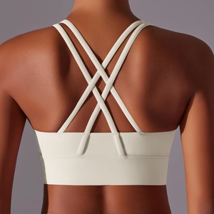 Dettaglio delle spalline incrociate e fascia ampia sul reggiseno sportivo crema