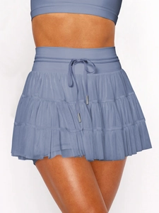 Detail of blue tiered mesh mini skirt showing high waist drawstring and metal tips