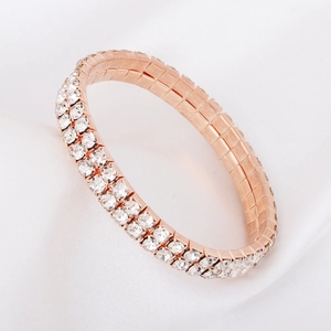 Detail of rose gold double row rhinestone stretch tennis bracelet on white silk fabric