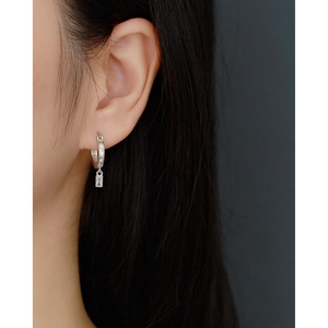 Close-up of s925 silver hoop earrings with a small rectangular zircon star charm