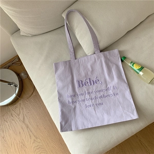 Nahaufnahme der hellvioletten Canvas-Einkaufstasche mit hochwertiger Stickerei auf Sofa