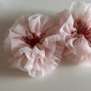 Detailed view of pink heavy lace scrunchies with ruffle texture and sheer tulle fabric