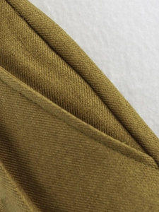 Macro detail showing the olive green twill fabric texture and professional stitching edges