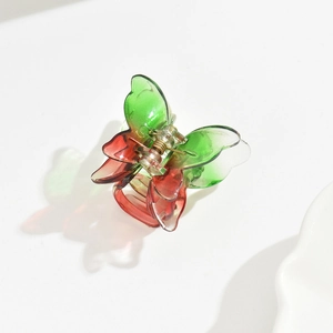 Macro view of a 3.5cm butterfly hair claw clip featuring green and red gradient colors