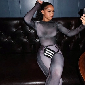 Close-up of slim fit purple gradient long sleeve top and matching pants on a sofa