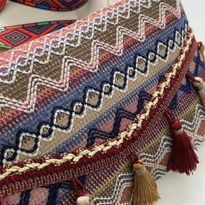 Detailed close-up of Bohemian embroidered bag with tassels and colorful weaving