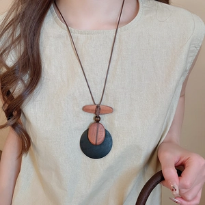 Detailed close-up of a vintage ethnic style long necklace with brown oval wood pendants