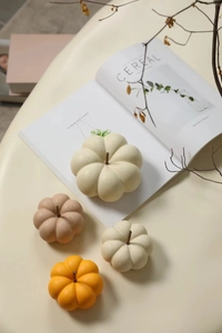Detail of four ceramic pumpkin ornaments in beige and orange for autumn home decor