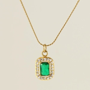 Close-up of 18K gold square necklace featuring an emerald green gemstone and zircon halo
