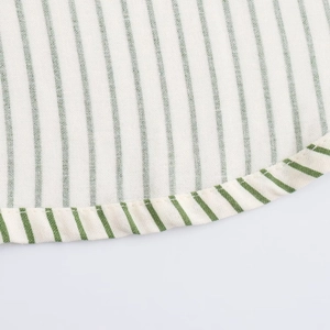 Détail du tissu à rayures vertes et blanches montrant l'ourlet arrondi et la couture