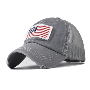 Detail of grey washed cotton baseball cap with American flag embroidery and distressed holes