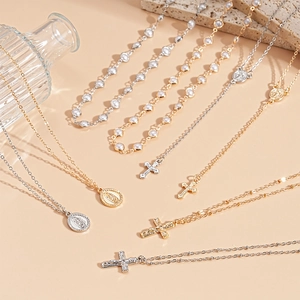 Four-piece gold and silver layered necklace set with pearls, cross, and oval medals