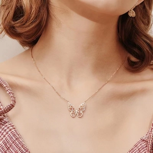 Detailed close-up of a butterfly pendant necklace with micro-pave cubic zirconia on a model