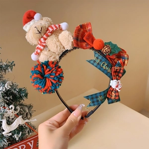 Close-up of Christmas bear headband with plush bear, red plaid bows and pine cones