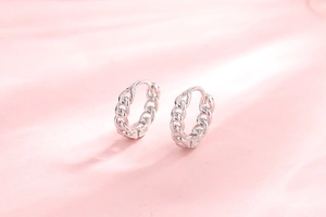 Detail of S925 sterling silver hoop earrings with a trendy Cuban chain design on silk